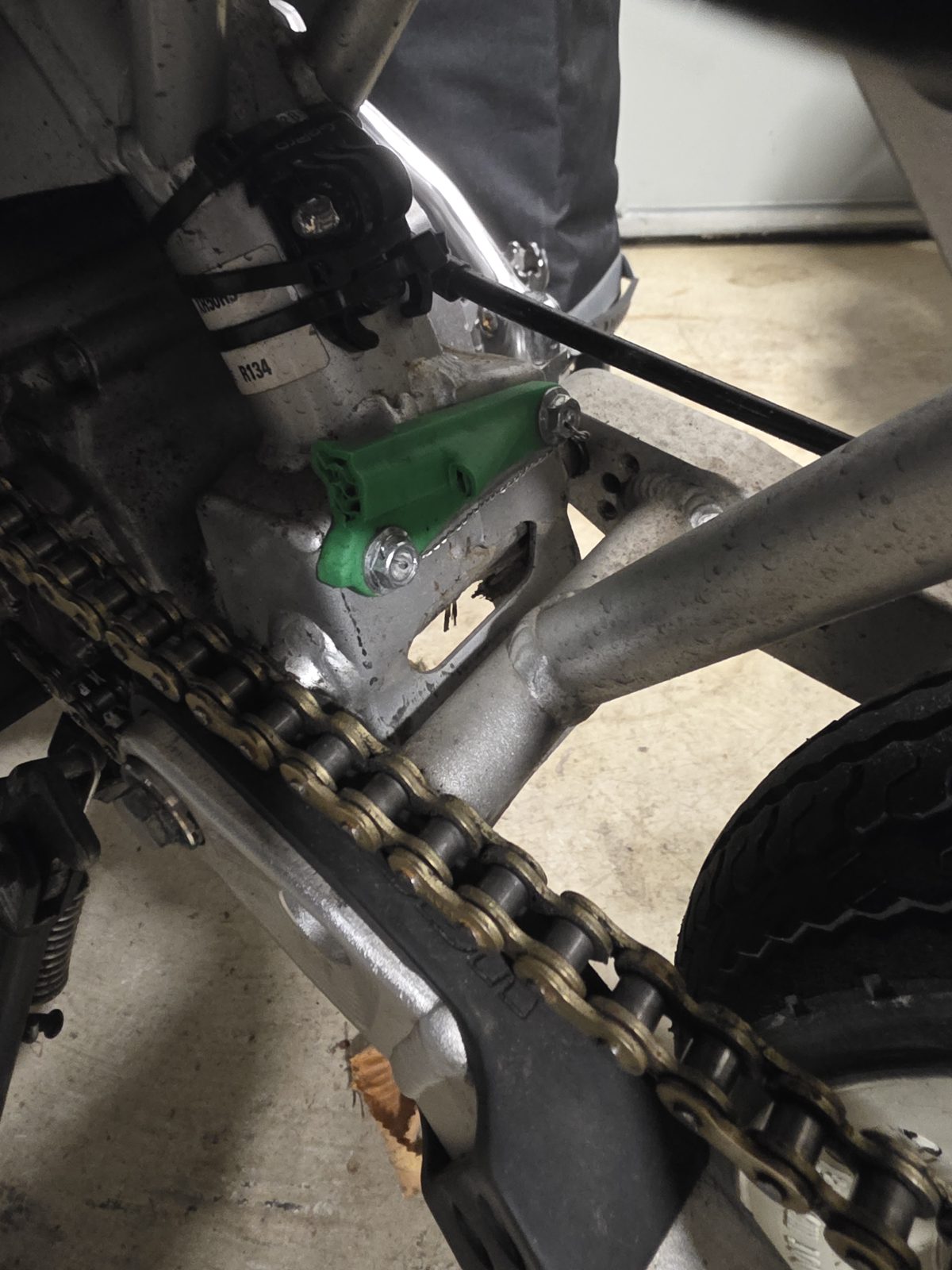 The broken original chain guard stub still bolted to the XR50 frame tab